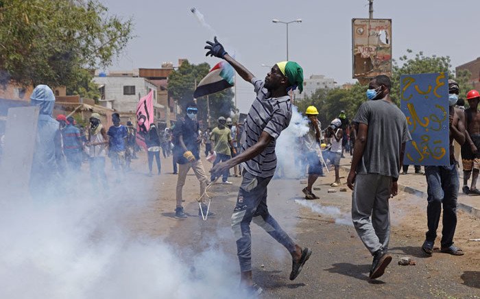 An anti-coup protester throws back a tear gas canister at security forces during clashes amdist mass demonstrations against military rule in the centre of Sudan's capital Khartoum on 30 June 2022. Picture: AFP