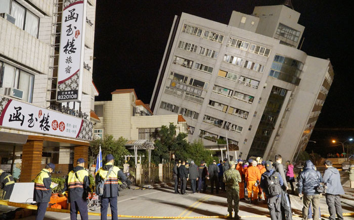 FILE: Rescue workers block off the area to search for survivors outside a building which tilted to one side after its foundation collapsed in Hualien after a strong 6.4-magnitude quake rocked eastern Taiwan early on 7 February 2018. Picture: AFP.