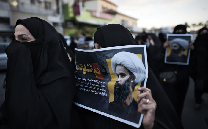 Bahraini women hold posters bearing portraits of prominent Shiite Muslim cleric Nimr al-Nimr during a protest against his execution by Saudi authorities, in the village of Jidhafs, west of the capital Manama on 3 January, 2016. Picture: AFP.