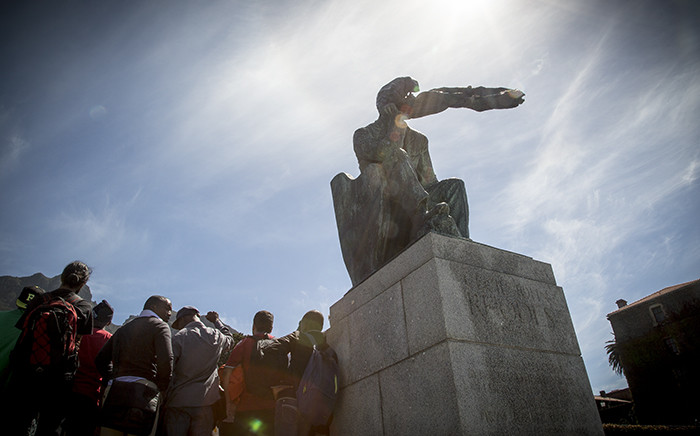 University of Cape Town students stand in front of the Rhodes statue on the campus, a black plastic bag over his head. Using the slogan "Rhodes Must Fall" they are demanding it be taken down as it represents institutional racism. Picture: Thomas Holder/EWN