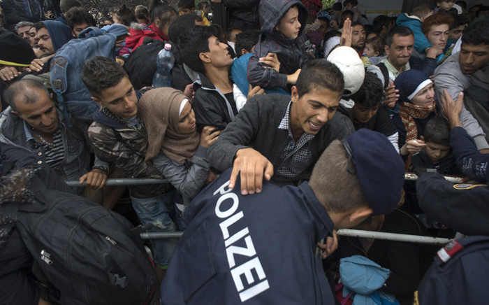 Hundreds of migrants struggle to board a train on 11 September, 2015 at a train station in Nickelsdorf, at the Austrian side of the border between Hungary and Austria. Picture: AFP.