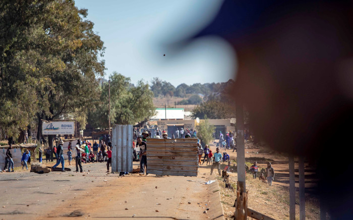 A protester hurls a stone towards a police line on a bridge spanning the R59 outside Sicelo informal settlement in Meyerton on 18 June 2018.  Picture: Thomas Holder/EWN.