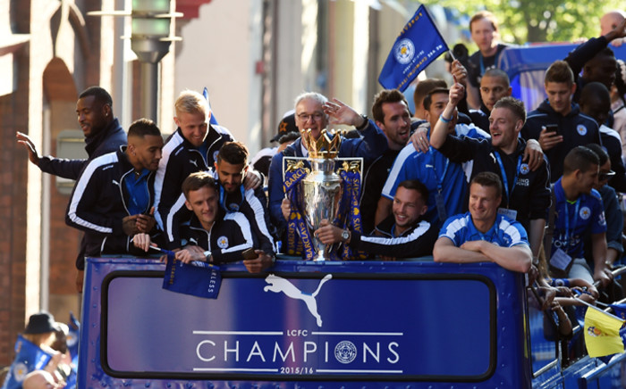 FILE: Leicester City’s Italian manager Claudio Ranieri (C) holds the Premier league trophy as the Leicester City team take part in an open-top bus parade through Leicester to celebrate winning the Premier League title on 16 May, 2016. Picture: AFP.