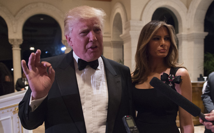 FILE: US President-elect Donald Trump answers questions from reporters accompanied by his wife Melania for a New Year's Eve party 31 December, 2016 at Mar-a-Lago in Palm Beach, Florida. Picture: AFP.