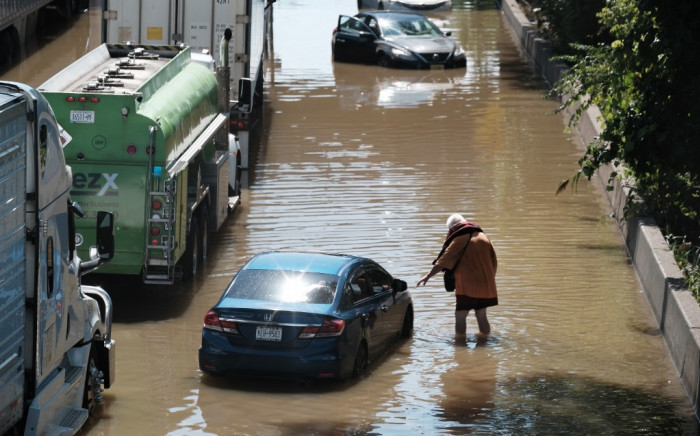 A person walks next to an abandoned car on the flooded Major Deegan Expressway following a night of extremely heavy rain from the remnants of Hurricane Ida on 2 September 2021 in the Bronx borough of New York City. Picture: Spencer Platt/AFP