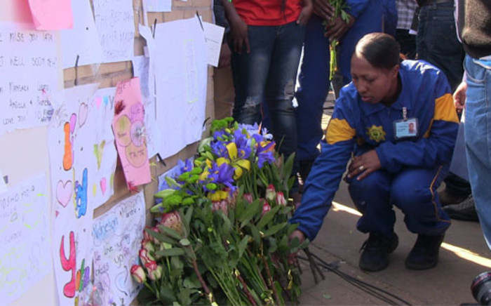 A Tshwane SAPS Academy student adds flowers to the wall of messages and well wishes for Madiba at the entrance of the Pretoria Heart Hospital.  Picture: Christa van der Walt/EWN.