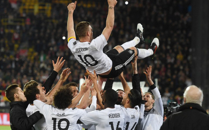 Teammates throw Germany's midfielder Lukas Podolski in the air after the friendly football match of Germany vs England in Dortmund, western Germany, on 22 March, 2017. It was Lukas Podolski’s last match with the German team. Picture: AFP.