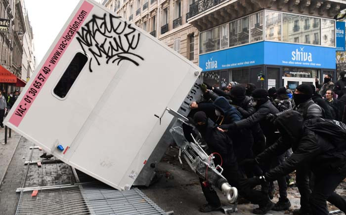 FILE: Demonstrators overturn a container during a demonstration against the pension overhauls, in Paris, on 5 December 2019 as part of a nationwide strike. Trains cancelled, schools closed: France scrambled to make contingency plans on for a huge strike against pension overhauls that poses one of the biggest challenges yet to French President's sweeping reform drive. Picture: AFP.
