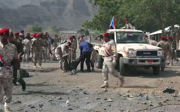 This AFPTV screengrab from a video made on 1 August 2019, shows Yemeni security forces carrying a body at the scene of a missile attack on a military camp west of Yemen's government-held second city Aden. Picture: AFP