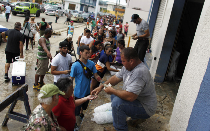 Hundreds of people line up to buy ice at a local plant in the aftermath of Hurricane Maria, in Arecibo, Puerto Rico, on 30 September 2017. Picture: AFP.