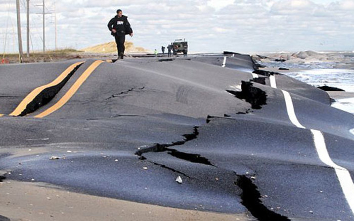 A sheriff walks on a New Jersey road damaged by Superstorm Sandy on 30 October 2012. Picture: Twitter