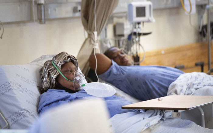 FILE: Two patients with COVID-19, one (L) breathing in oxygen, in the COVID-19 ward at Khayelitsha Hospital, about 35km from the centre of Cape Town, on 29 December 2020. Picture: RODGER BOSCH/AFP