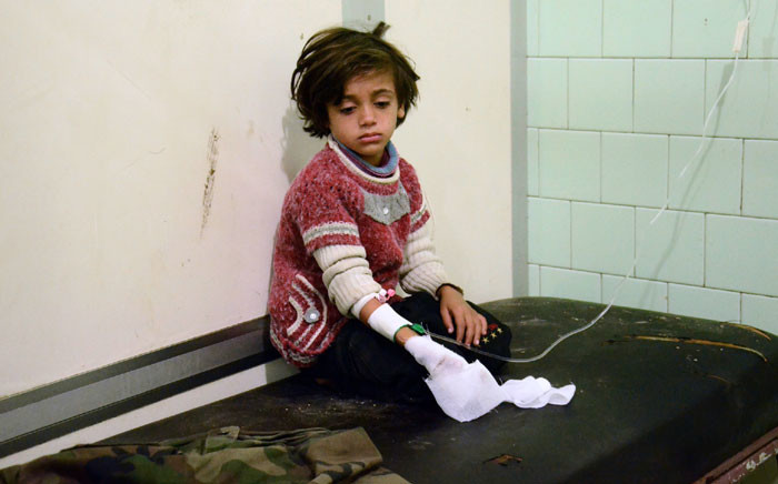 FILE: An injured child waits after receiving treatment at the University hospital in a government-held neighbourhood following reported rebel fire on government-held parts of the northern city of Aleppo. Picture: AFP.