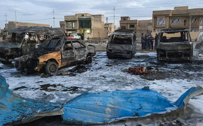 File: A picture taken with a mobile phone shows burnt vehicles at the scene of a blast by a massive car bomb, which killed dozens in a used car market in southern Baghdad. Picture: AFP