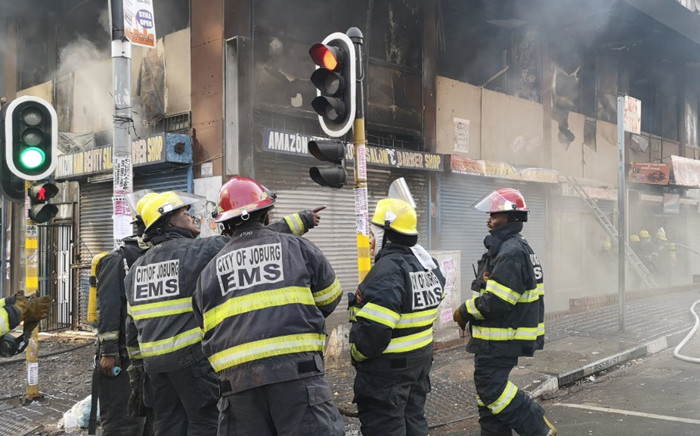 FILE: Firefighters attend to a burning building on the corner of De Villiers and Rissik street in Johannesburg. Picture: EWN