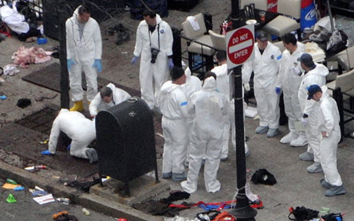 Investigators in white jumpsuits work the crime scene on Boylston Street following the bomb attack at the Boston Marathon April 16, 2013 in Boston, Massachusetts. Picture: AFP.