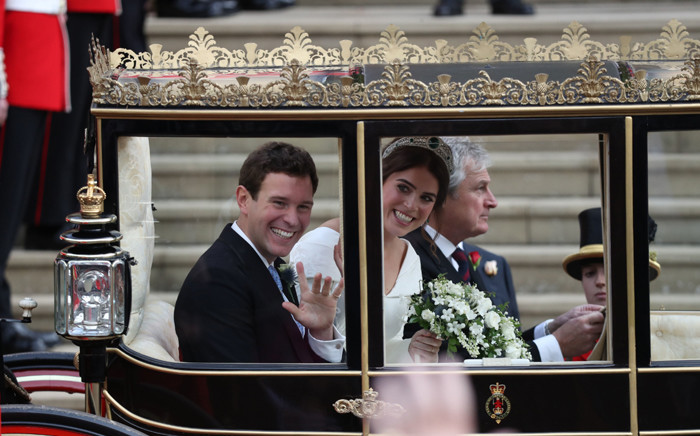 Britain's Princess Eugenie of York (R) and her husband Jack Brooksbank (L) get into the Scottish State Coach at the start of their carriage procession following their wedding at St George's Chapel, Windsor Castle in Windsor, on 12 October 2018. Picture: AFP