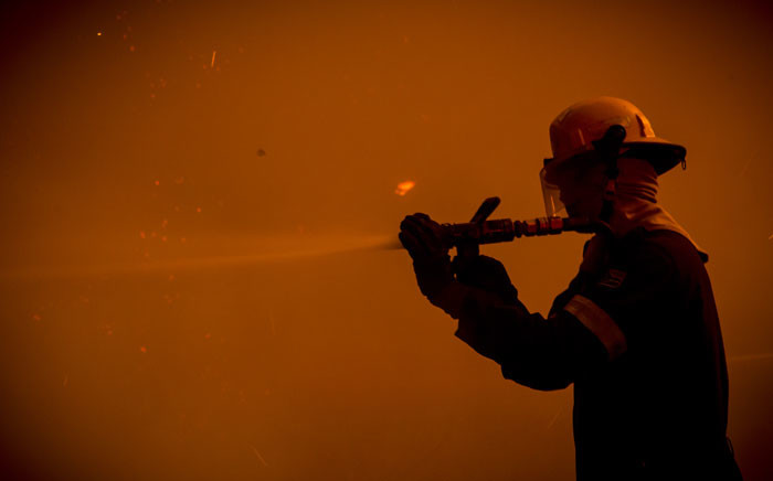 A Cape Town firefighter battles the blaze. Picture: Thomas Holder/EWN.