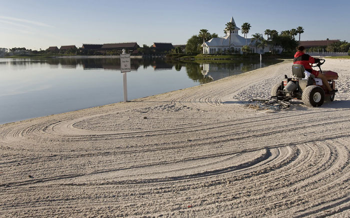 This file photo taken on 11 April 2008 shows a groundsman rake the beaches of Disney's Grand Floridian Resort & Spa at Disney World in Orlando, Florida. Picture: AFP.