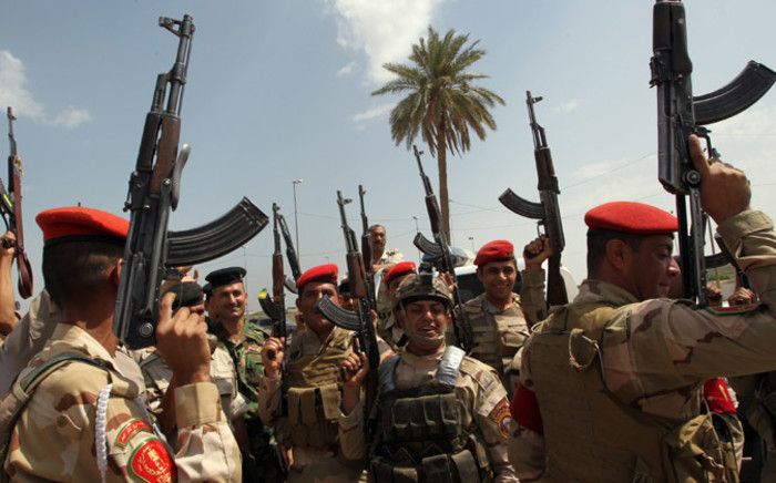 FILE: Iraqi army troops chant slogans against the Islamic State of Iraq and the Levant (ISIL) as they recruit volunteers to join the fight against a major offensive by the jihadist group in northern Iraq, outside a recruiting centre in the capital Baghdad on 13 June 2014. Picture: AFP.