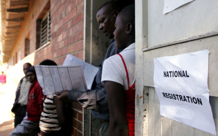 FILE: A voter registration official inspects identity particulars at Lotshe Primary School in Bulawayo, Zimbabwe on 7 May 2013 during the mobile voter registration exercise. Picture: AFP