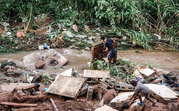 FILE: A man tries to salvage some of his furniture at an informal settlement of BottleBrush, south of Durban, after torrential rains and flash floods destroyed his home on 23 April 2019. Picture: AFP