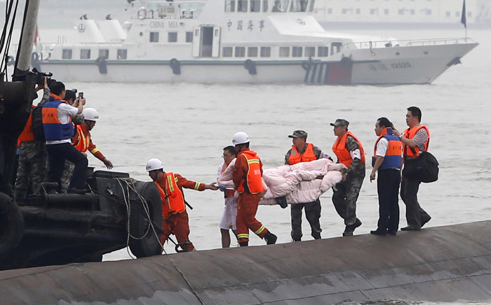 Chinese rescue workers remove the body of a victim from the capsized Dongfangzhixing or “Eastern Star” vessel which sank in the Yangtze river in Jianli, central China’s Hubei province on 2 June, 2015. Picture: AFP.