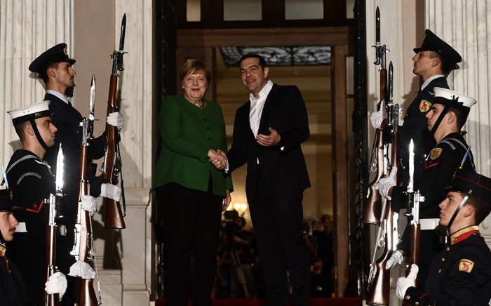 Greece's Prime Minister Alexis Tsipras (R) shakes hands with German Chancellor Angela Merkel as she arrives in Athens on 10 January 2019. Picture: AFP