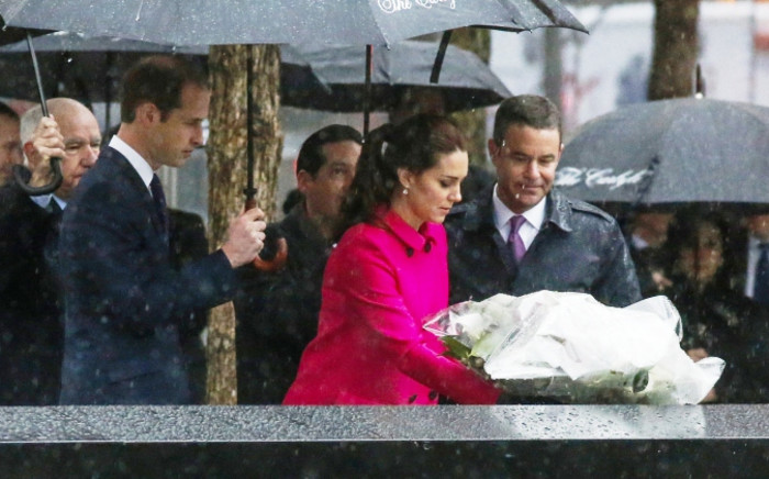 The Duchess Of Cambridge (C) lays a wreath for 9/11 victims next to the Duke of Cambridge (2nd-L ) while the royal couple pause for reflection in the Memorial Plaza at ground zero on 9 December 2014 in New York. Picture: AFP.