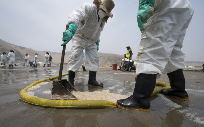 Cleaning crews work to remove oil from the Cavero Beach in Callao, Peru, on 26 January 2022. Picture: Cris Bournocle/AFP