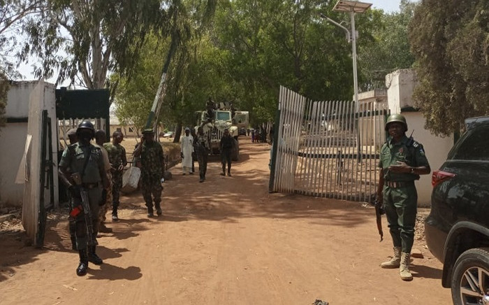 Nigerian soldiers and police officers stand at the entrance of the Federal College of Forestry Mechanisation in Mando, Kaduna state, on March 12, 2021, after a kidnap gang stormed the school shooting indiscriminately before taking at least 30 students around 9:30pm (2030 GMT) on March 11, 2021. Picture: Bosan Yakusak /AFP.