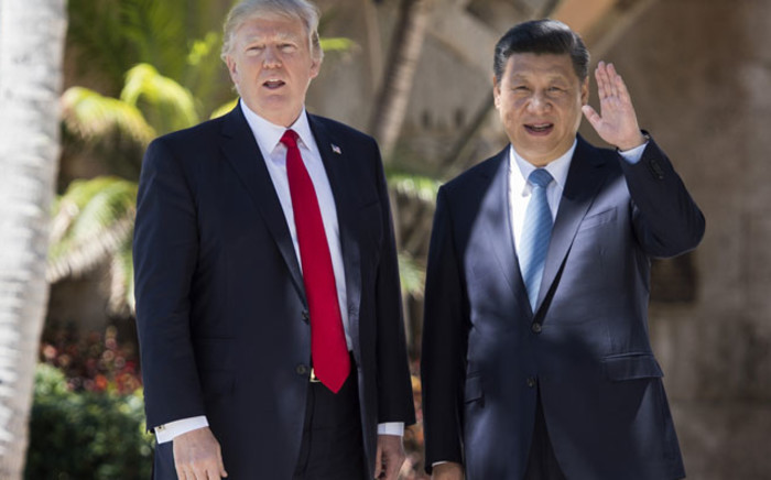Chinese President Xi Jinping (R) waves to the press as he walks with US President Donald Trump at the Mar-a-Lago estate in West Palm Beach, Florida, April 7, 2017. Picture: AFP.