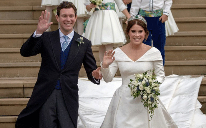 Britain's Princess Eugenie of York (R) and her husband Jack Brooksbank wave as they emerge from the West Door of St George's Chapel, Windsor Castle, in Windsor, on October 12, 2018 after their wedding ceremony. Picture: AFP.