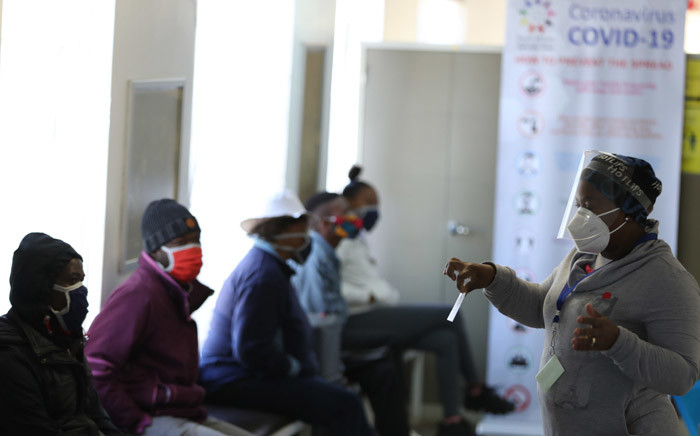 A medical worker addresses some of the first South African Oxford vaccine trialists waiting ahead of the clinical trial for a potential vaccine against COVID-19 at the Baragwanath hospital in Soweto on 24 June 2020. Picture: AFP