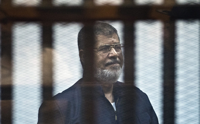 File: Egypt's ousted Islamist president Mohamed Morsi stands behind the bars during his trial in Cairo on 16 June, 2015. Picture: AFP.