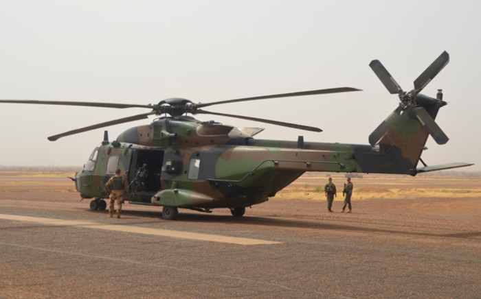 A photo taken on 25 July, 2017 shows a German helicopter crew near their NH90 Caiman transport helicopter on the ground at Gao airport in Mali. Picture: AFP.