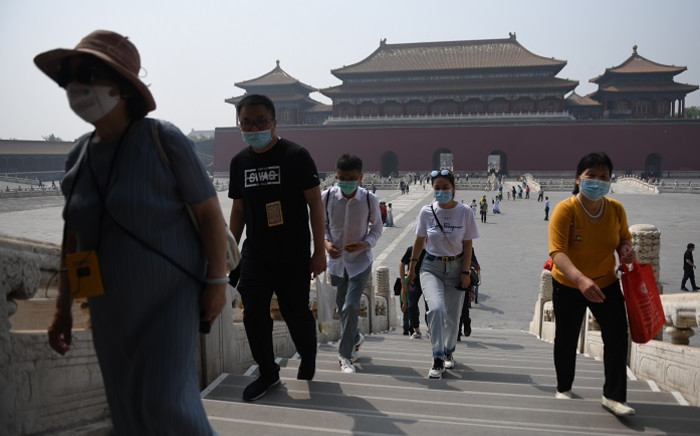 FILE: People wear face masks as a preventive measure against the COVID-19 coronavirus as they walk through the Forbidden City, the former palace of China's emperors, in Beijing on 1 May 2020. Picture: AFP