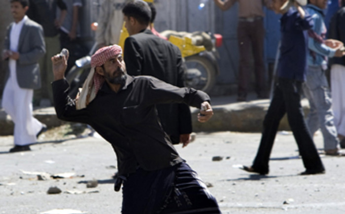 Yemeni anti-government protesters throw stones towards regime loyalists during clashes in central Sanaa. Picture: AFP 