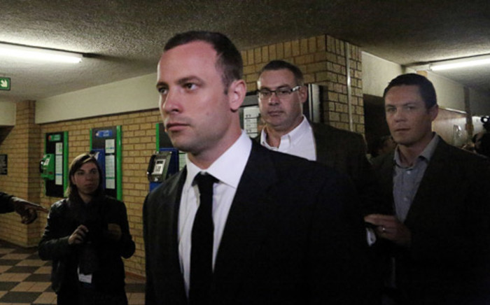 Oscar Pistorius is escorted into the High Court in Pretoria on the first day of his trial for murder. Picture: Sebabatso Mosamo/EWN.