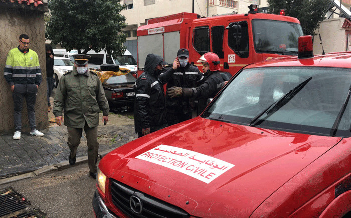 Emergency services gather at the site of illegal underground textile workshop that flooded after heavy rain fall in Morocco's city of Tangiers on February 8, 2021.  Picture: AFP.