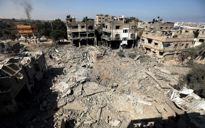 Palestinians walks across the rubble of destroyed buildings and homes in Al-Salam neighbourhood, in Jabalia in the northern Gaza Strip on 1 August 2014. Picture: AFP.
