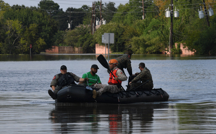 Military and state troopers help evacuate a man beside the spillway area of the Barker Reservoir in the Coldine are a after Hurricane Harvey caused widespread flooding in Houston, Texas on 31 August 2017. Picture: AFP.