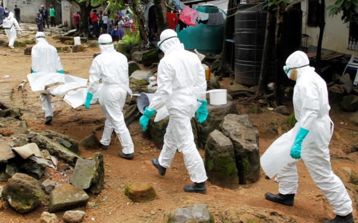 FILE: Nurses carry the body of a suspected victim of Ebola at the Sonuwein community in Monrovia, Liberia, 3 October 2014. Picture: EPA/Ahmed Jallanzo.