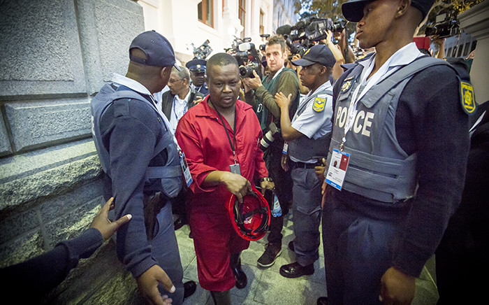 An Economic Freedom Fighters Member of Parliament is being escorted out of Parliament after they were kicked out during the State of the Nation Address in Cape Town on 12 February 2015. Picture: Thomas Holder/EWN.