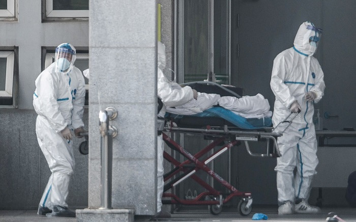 Medical staff members carry a patient into the Jinyintan hospital, where patients infected by a mysterious SARS-like virus are being treated, in Wuhan in China's central Hubei province on 18 January 2020. Picture: AFP