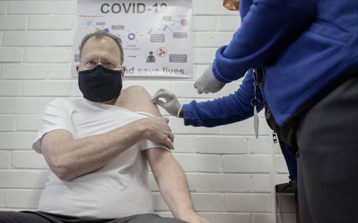 FILE: Professor Martin Veller (L), the Dean of the Faculty of Health Sciences at the University of the Witwatersrand (Wits University), receives an experimental vaccine for COVID-19 coronavirus at the Respiratory & Meningeal Pathogens Research Unit (RMPRU) at Chris Hani Baragwanath Hospital in Soweto on 14 July 2020. Six senior clinicians in the Faculty of Health Sciences at Wits University have volunteered to participate in South Africa’s first COVID-19 vaccine trial. Picture: AFP