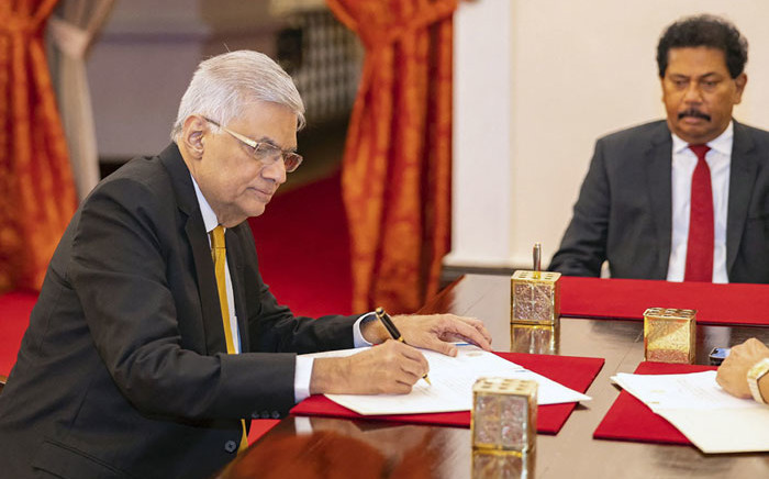 FILE: This handout photograph taken on 12 May 2022 and released by Sri Lanka President's Office shows the new prime minister Ranil Wickremesinghe (L) attending his swearing in ceremony at the President's Palace in Colombo. Picture: Sri Lanka President's Office / AFP