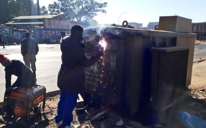 City Power workers weld up an electricity power box to prevent access to cable thieves and vandals. Picture: @JoburgMPD/Twitter