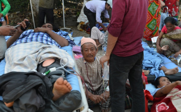 Nepalese patients lie on stretchers in an open area after being carried out of a hospital building as a 7.3 magnitude earthquake hits the country, in Kathmandu, on May 12, 2015. Picture: AFP.