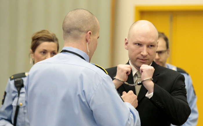 FILE: Norwegian mass killer Anders Behring Breivik (R) has his handcuffs removed inside the courtroom in Skien prison, 16 March, 2016. Picture: AFP.
